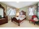 A cozy bedroom features a wooden bed frame, floral print, and natural light from the dual windows at 17298 E Lake Pl, Aurora, CO 80016