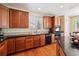 Charming kitchen featuring wood cabinets, tile countertops, and sleek black appliances for modern convenience and style at 17298 E Lake Pl, Aurora, CO 80016