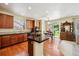 Bright kitchen featuring wood cabinets, black countertops, an island, and an adjacent dining area for Gathering meals at 17298 E Lake Pl, Aurora, CO 80016