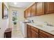 Bright laundry room with front-loading washer and dryer, wooden cabinets, and a window with backyard view at 17298 E Lake Pl, Aurora, CO 80016