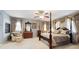 Elegant primary bedroom with four-poster bed, fireplace, and sitting area at 17298 E Lake Pl, Aurora, CO 80016