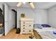 Bright bedroom featuring a full bed, light colored walls, wood floors and a chest of drawers at 8430 Madison Way, Denver, CO 80229