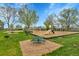 View of a community playground showing swings, slides, lush lawns and park amenities at 8430 Madison Way, Denver, CO 80229