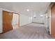 Open basement area featuring finished carpet, wall paneling, and storage at 1994 Macon St, Aurora, CO 80010
