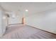 Finished basement space with neutral carpet, wainscotting, and access to the upstairs at 1994 Macon St, Aurora, CO 80010