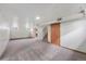 Spacious basement area with finished carpet, partial wall panels, and storage at 1994 Macon St, Aurora, CO 80010