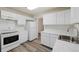 Kitchen with white cabinets, marble countertops, and modern appliances at 1994 Macon St, Aurora, CO 80010