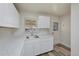 Renovated kitchen features white cabinets and a stainless steel sink at 1994 Macon St, Aurora, CO 80010