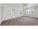 Living room featuring neutral carpet, ceiling fan, and a charming entry door at 1994 Macon St, Aurora, CO 80010