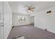 Bright living room boasts neutral paint, carpet, a ceiling fan, and ample natural light at 1994 Macon St, Aurora, CO 80010