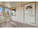 Bright, enclosed front porch features neutral paint, wood-look floor, and windows at 1994 Macon St, Aurora, CO 80010