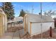 Exterior angle of the shed with white and yellow trim and peaked roof at 1994 Macon St, Aurora, CO 80010