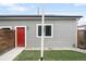 Backyard features a well-maintained green lawn and a gray house facade with a red door at 4730 S Acoma St, Englewood, CO 80110
