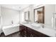 Elegant bathroom featuring double sinks, a soaking tub, and modern fixtures at 4730 S Acoma St, Englewood, CO 80110