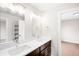Bathroom featuring double sinks, modern lighting, and a view into an adjacent room at 4730 S Acoma St, Englewood, CO 80110