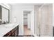 Modern bathroom featuring a glass shower, sleek vanity, and access to a walk-in closet at 4730 S Acoma St, Englewood, CO 80110
