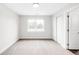 Bright bedroom featuring a large window, neutral carpet, and closet with sliding doors at 4730 S Acoma St, Englewood, CO 80110