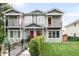 Inviting home featuring gray siding, red doors, black metal railings, and a well-manicured lawn at 4730 S Acoma St, Englewood, CO 80110