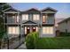 Charming two-story townhouse features gray siding, red doors, inviting balconies, and professionally maintained landscaping at 4730 S Acoma St, Englewood, CO 80110