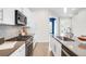 Stylish kitchen featuring white cabinets, stainless steel appliances, decorative backsplash, and plenty of counter space at 4730 S Acoma St, Englewood, CO 80110