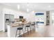 Modern kitchen featuring white cabinets, stainless steel appliances, a large island with seating, and stylish backsplash at 4730 S Acoma St, Englewood, CO 80110