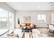 Well-lit living room featuring a modern leather couch, stylish decor, and seamless flow to the dining area at 4730 S Acoma St, Englewood, CO 80110