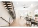 A modern living space with wooden staircase, sleek fan, dining table, and comfortable seating at 4730 S Acoma St, Englewood, CO 80110