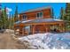 Exterior view of mountain home featuring a covered porch, wood siding, and snow-covered surroundings at 532 Kimmes Ln, Breckenridge, CO 80424