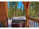 Exterior view of a hot tub on a deck with snow and surrounding pine trees at 532 Kimmes Ln, Breckenridge, CO 80424