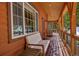 Inviting covered porch with wood ceiling and railing, plus seating for enjoying the snowy landscape at 532 Kimmes Ln, Breckenridge, CO 80424