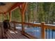 Exterior porch featuring wood beams and black metal railing overlooking snowy wooded landscape at 532 Kimmes Ln, Breckenridge, CO 80424