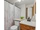 Cozy bathroom featuring a vanity with a wood cabinet and a shower with floral curtain at 6742 S Independence St, Littleton, CO 80128