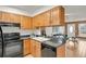 Well-organized kitchen with black appliances, wooden cabinets, and an open layout at 6742 S Independence St, Littleton, CO 80128