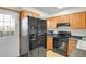 Efficient kitchen with black appliances, wooden cabinetry, and easy access to the backyard at 6742 S Independence St, Littleton, CO 80128