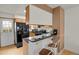 Functional kitchen with breakfast bar, black appliances, and ample cabinet space at 6742 S Independence St, Littleton, CO 80128