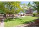 Lush backyard featuring a large lawn, patio with seating, mature trees, and well-maintained landscaping at 11345 Marshall Ct, Westminster, CO 80020