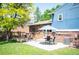 Landscaped backyard featuring a brick home, well-kept lawn, mature trees, and patio with outdoor seating at 11345 Marshall Ct, Westminster, CO 80020