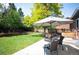 Backyard patio with outdoor seating under a shade umbrella, surrounded by a lush green lawn at 11345 Marshall Ct, Westminster, CO 80020