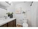 Well-lit bathroom features a wood-look floor, modern vanity, decorative mirror, and shower with curtain at 11345 Marshall Ct, Westminster, CO 80020