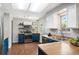 Well-appointed kitchen features stainless steel appliances, blue cabinets, butcher block counters, and plenty of natural light at 11345 Marshall Ct, Westminster, CO 80020