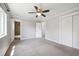 Spacious primary bedroom featuring a fan, neutral carpeting, ensuite bathroom, and closet at 11345 Marshall Ct, Westminster, CO 80020