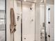 Clean shower featuring white tile, glass doors, modern fixtures, and a bright interior at 42729 Ivydel Cir, Elizabeth, CO 80107