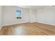 Empty bedroom with hardwood floors, white walls, a large window, and base trim at 5439 Westin Hills Dr, Elizabeth, CO 80107