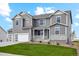 Charming two-story home with gray siding, stone accents, manicured lawn, and an attached two car garage at 5439 Westin Hills Dr, Elizabeth, CO 80107