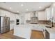 Modern kitchen with stainless steel appliances, white cabinetry, a center island, and hardwood floors at 5439 Westin Hills Dr, Elizabeth, CO 80107