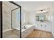Modern bathroom features a glass shower, soaking tub, white cabinets, and wooden floors at 5439 Westin Hills Dr, Elizabeth, CO 80107