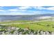 Sweeping aerial view showcases neighborhood and a nearby lake, mountains, and highway at 8544 S Upham Way, Littleton, CO 80128