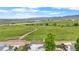 Stunning aerial view of a home with beautiful green space and lake views in the background at 8544 S Upham Way, Littleton, CO 80128