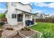 Wide backyard with a covered patio, chairs, grill, grass, and a planter bed at 8544 S Upham Way, Littleton, CO 80128