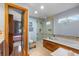 Bright bathroom boasts an enclosed shower and a luxurious soaking tub for relaxing at 8544 S Upham Way, Littleton, CO 80128